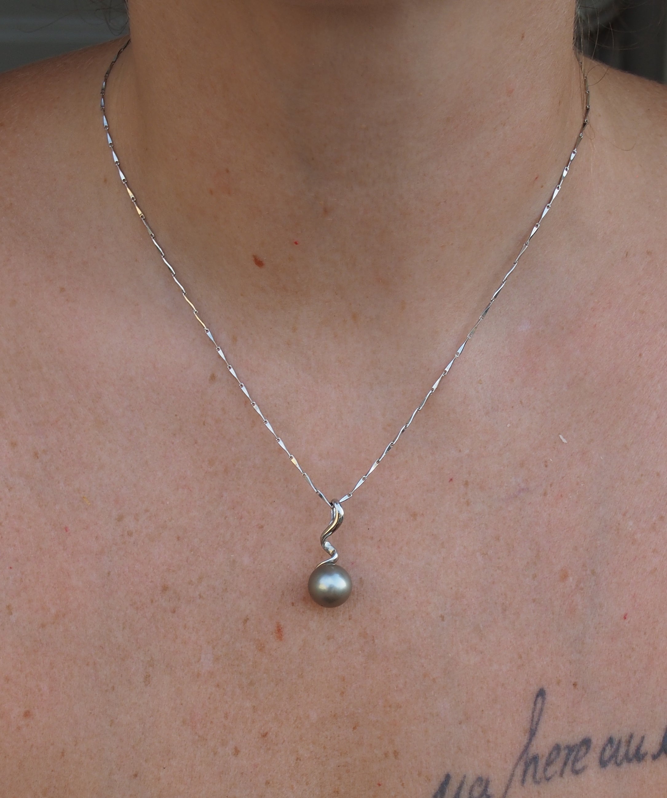 Collier FAAITE en argent 925 avec perle de Tahiti grise de 10,2 mm présenté sur nacre naturelle