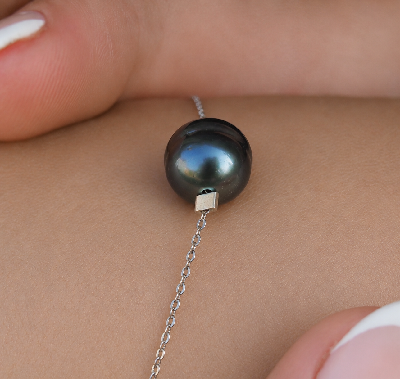 Gros plan sur une perle de Tahiti aubergine aux reflets noirs montée sur bracelet argent 925